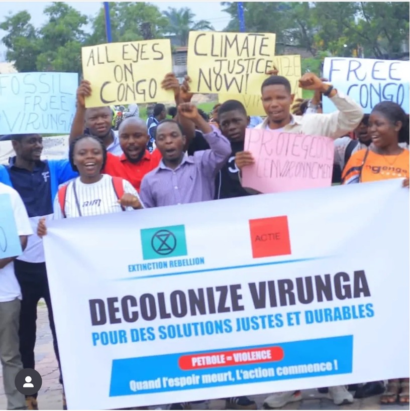 XR Rutshuru Rebell:innen mit einem Schild, "DECOLONIZEVIRUNGA"